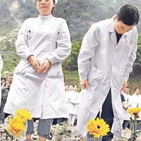 北川一批醫護人員在地震遺址獻花，悼念遇難親友。	美聯社圖片