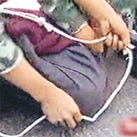 疑犯被警員用繩綁起。	電視圖片