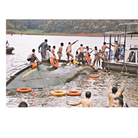 救援人員從翻沉遊船撈起屍體。美聯社圖片
