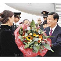 習近平在機場接受中國留學生代表獻花。新華社圖片