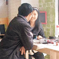 一對情侶在店內邊寫信邊閒聊。