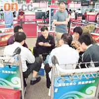 滯留在深圳機場的旅客，玩啤牌消磨時間。	黃熙攝