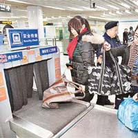乘客在上海地鐵站接受安檢。(新華社圖片）