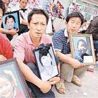 家長手持子女遺照控訴豆腐渣工程。(資料圖片）