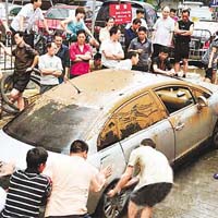 廣州龍口西路一小區，數十人合力推出一輛被浸五十多小時私家車。