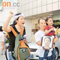 港人丈夫抱着女兒，與亡妻姊姊到醫院外抗議。	黃少君攝