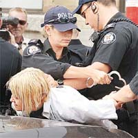 女示威者被制服，鎖上手銬。