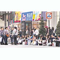 中國遊客在銀座購物滿載而歸，帶着大包小包坐在路邊休息。(資料圖片)