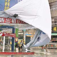 高雄<br>市區昨風雨交加，廣告帆布被強風吹落。