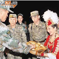 哈薩克姑娘向參加軍演的中方官兵，獻上傳統美食。	(新華社圖片）