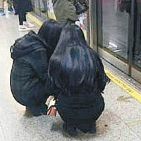 滬兩女蹲地鐵月台玩手機