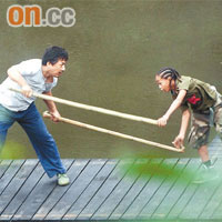 成龍與積登在河邊比試木棍。	《CFP》
