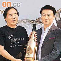 羅傑承（右）由葉澍堃手上接過以十萬元投得的香檳。