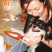 Janice Man和愛犬慶祝生日，抱着小狗切蛋糕。