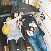 Kelly不停以雨傘為兒子劉昇擋雨兼遮鏡頭。