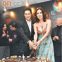 穿低胸裝的寇鴻萍與老公梁廷鏘切蛋糕，慶祝餐廳一周年紀念。