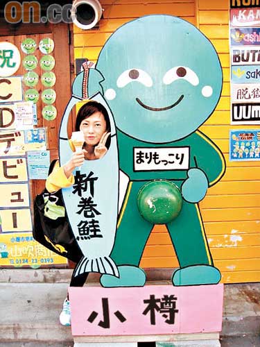 汀叮去年到北海道小樽旅行，手持雪糕與熱爆的霉菌公仔合照。