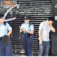  報稱受傷的《壹週刊》記者（右）接受警方查問。