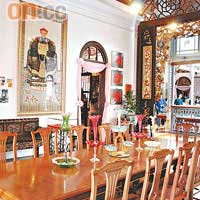博物館的飯廳，長形西式餐枱配牆上大幅祖先掛畫，中西合璧。