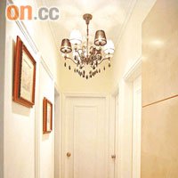 設計師在走廊掛上屋主精心挑選的燈飾，並加上一幅幅掛畫，營造外國家居的風格。