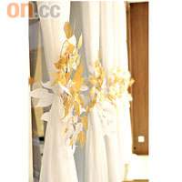 落地玻璃窗前綴上白色長紗，再配以淡金色的葉子裝飾，簡單而華麗。 