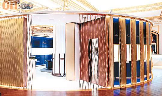 Breguet   <br>開放式的圓柱體形設計，跟藝術中心天花板的尖形棱角設計形成強烈對比，店內採用寶藍色調玻璃裝飾及金屬支架，靈感源自品牌的手錶設計。