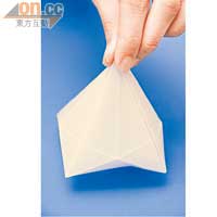4. 按着中間的八角形位置，把紙慢慢向上摺起，完成後會成糉子狀。