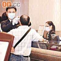 帝京酒店職員用體溫計為旅客量度體溫。