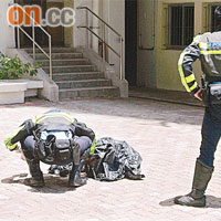 警員檢查墮樓青年屍首。