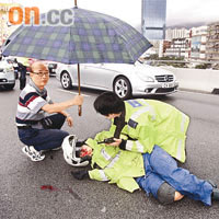 陳姿迪滿面鮮血躺在路面，路過司機為其打傘擋雨。
