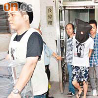 警方拘捕被告（蒙頭者）後，到其寓所搜查，檢走電腦等物品。	資料圖片