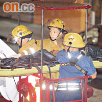 消防員利用升降台將墮樓老翁的屍體由平台抬下。