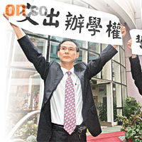 鄧仲明（左）與梁淑貞昨展示標語，辯稱交回辦學權是負責任行為。