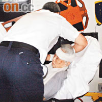 救護員為老婦包紮傷口。