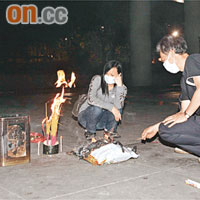 余母在男親友陪同下到兇案現場拜祭兒子，神情哀傷。