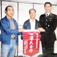周良華（左）於一九九二年曾協助警方破案，獲牛頭角警署頒發錦旗致謝。 受訪者提供