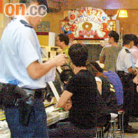 警員在電子遊戲機舖查閱顧客身份證。