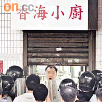 男子拉下捲閘與警對峙。