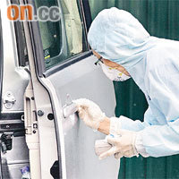 鑑證科人員在死者的私家車掃模蒐證。