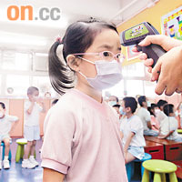 幼兒園老師每天為學童量體溫，留意他們的健康狀況。