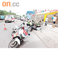 兩名受傷騎警分別躺地及挨在樹旁待救，肇事兩部鐵馬翻側在路面。