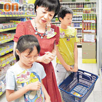 劉燕卿（中）教兩位小朋友格價同埋要特別留意營養標籤。