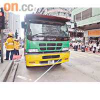 消防員協助將屍體由貨車底拖出。