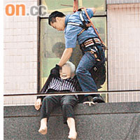 消防員將危坐簷篷老婦救回。