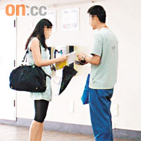 家長黃先生（化名，右）在港鐵站交收在網上成功出售的課本。