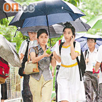 這名女同學冒雨到聯招中心找學位，親友不辭勞苦在旁撐傘支持。