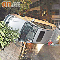 私家車被代客泊車職員撞毀，「騎」在花槽上。