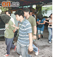 被捕疑犯蒙頭押走。