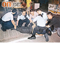 警員與街坊合力將疑人制服，按在地上。