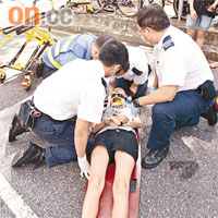 長腿嬌娃受傷倒地，救護員為她敷治。